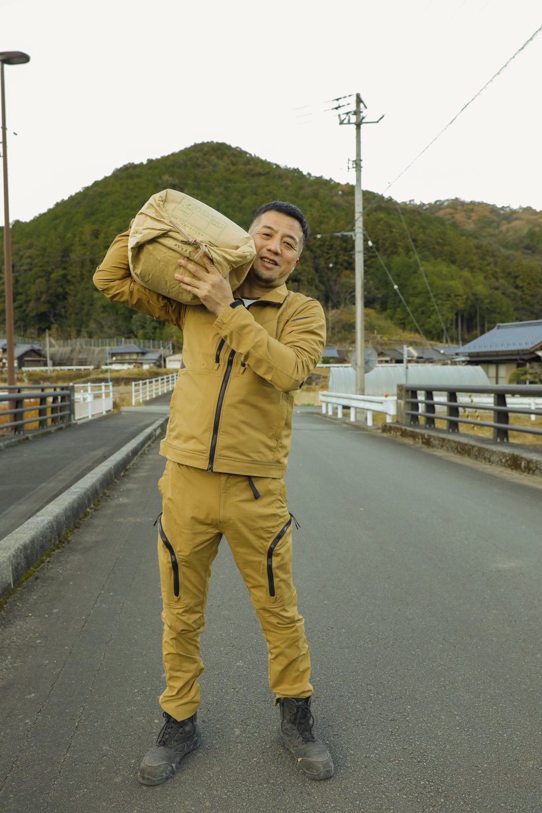収穫したお米を担ぐ河野亮二さん