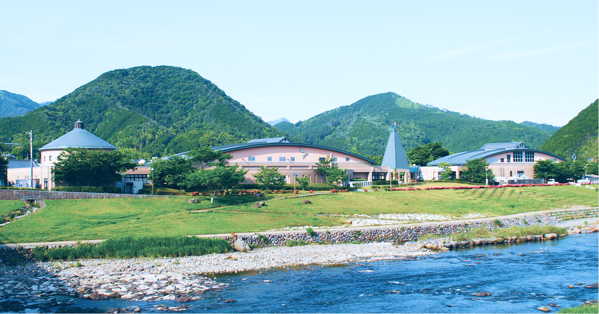 道の駅「虹の森公園 松野町」と川、背景に緑の山々が広がる松野町の風景